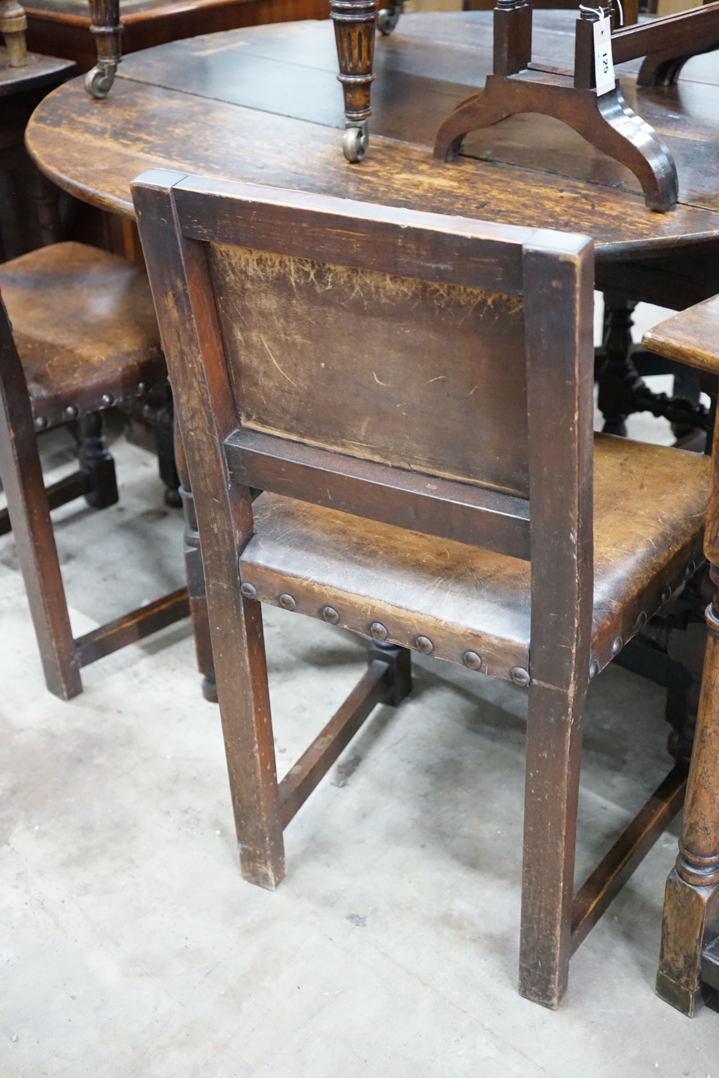 A set of six Carolean style oak and studded leather dining chairs